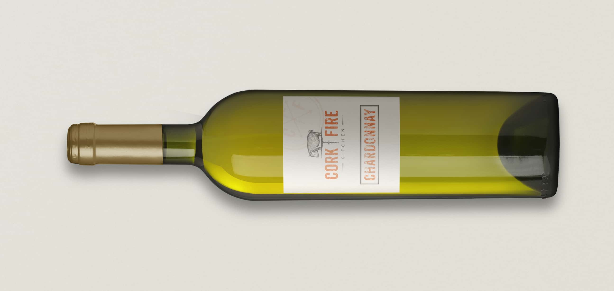 A bottle of 'CORK & FIRE Chardonnay' wine lying on its side, with a simple and elegant label indicating the wine variety and brand.