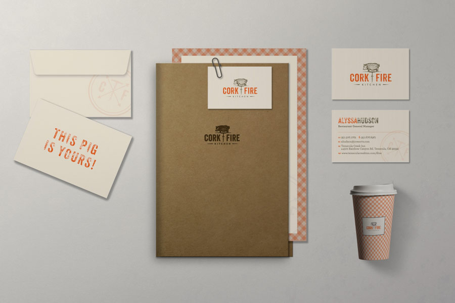 Restaurant branding materials for Cork | Fire Kitchen including business cards, envelope, letterhead, coffee cup, and folder with rustic and checkered orange patterns.